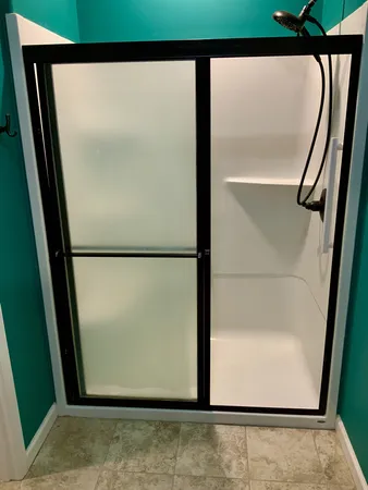 an empty room with wooden floor closet and windows