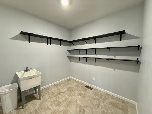 a view of a room with wooden floor a table and a painting