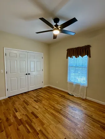 a view of a room with wooden floor and a table