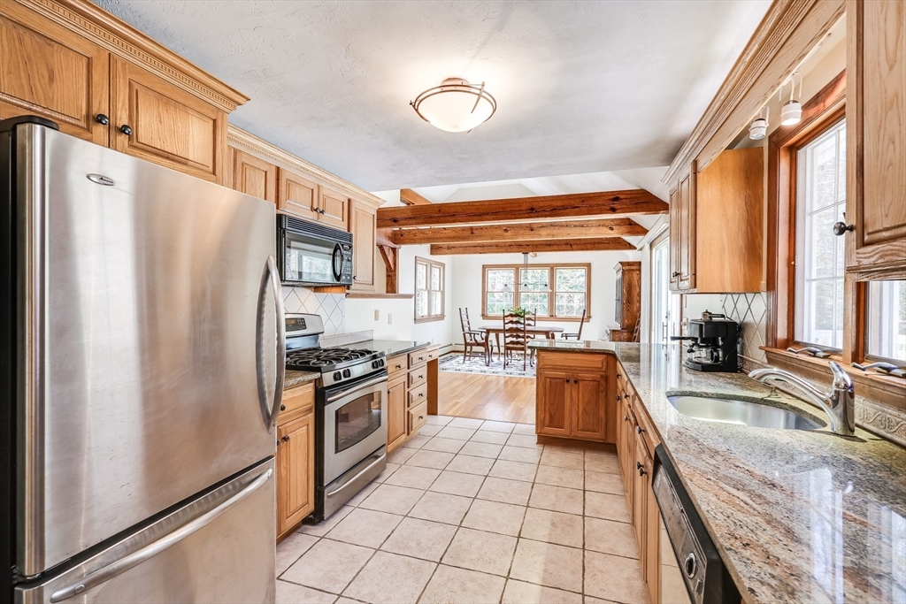 59 Valley Road Brewster, MA 02631 - Photo 5 of 42 a kitchen with stainless steel appliances granite countertop a refrigerator a stove and a sink with wooden floor