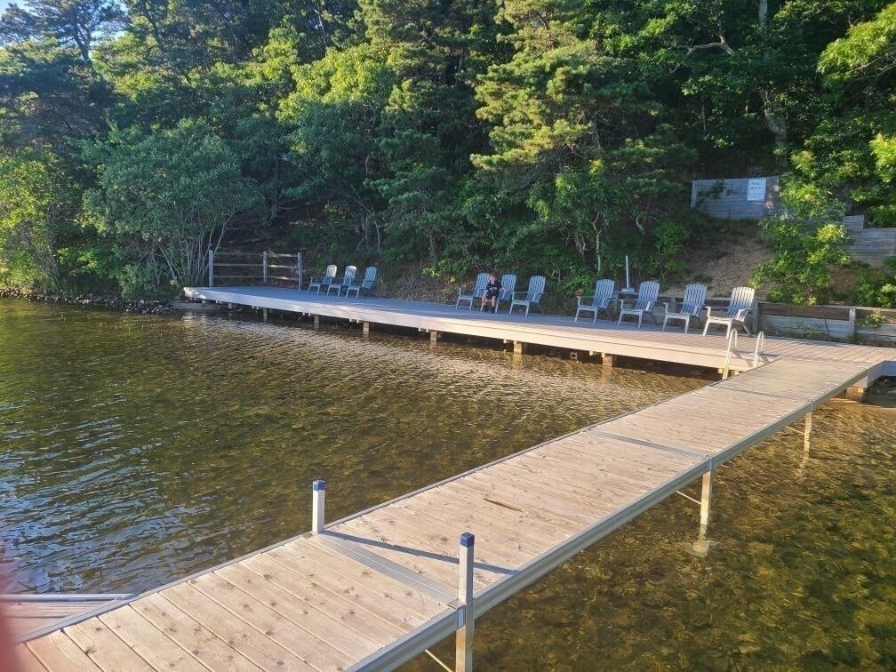 59 Valley Road Brewster, MA 02631 - Photo 8 of 42 a view of a lake with chairs