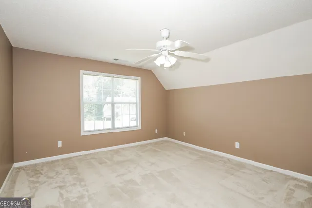 en empty room with windows and ceiling fan