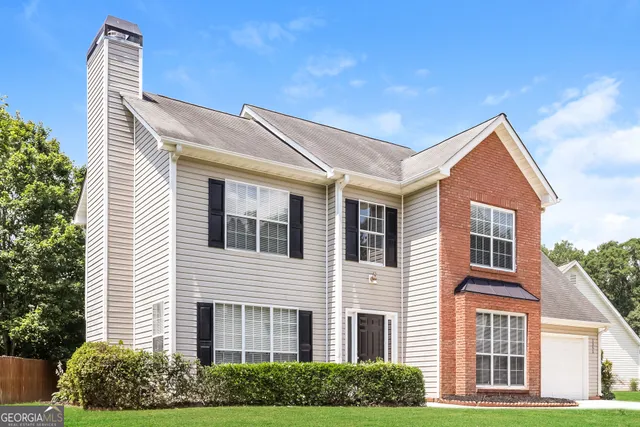 a front view of a house with plants