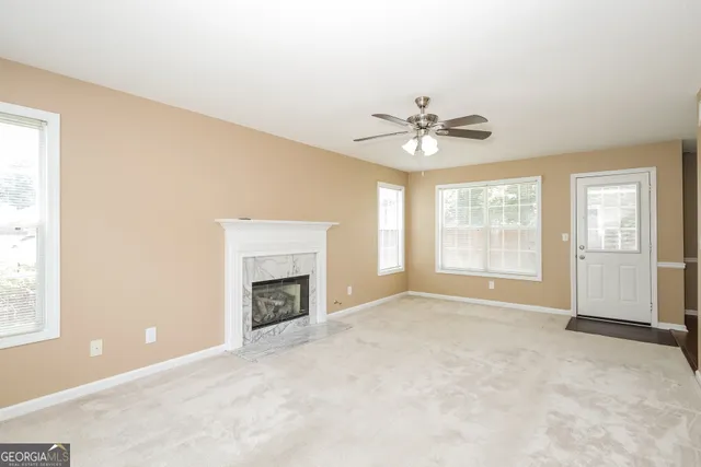 an empty room with windows and fireplace