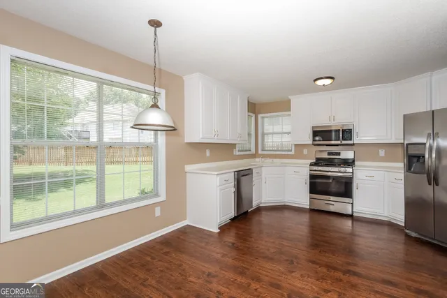 a kitchen with a refrigerator and a stove top oven