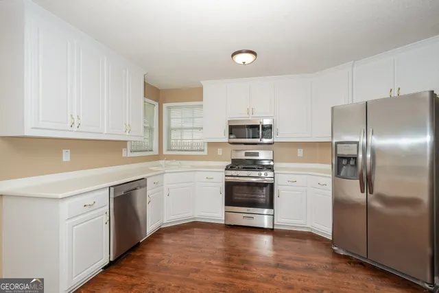a kitchen with stainless steel appliances and white cabinets
