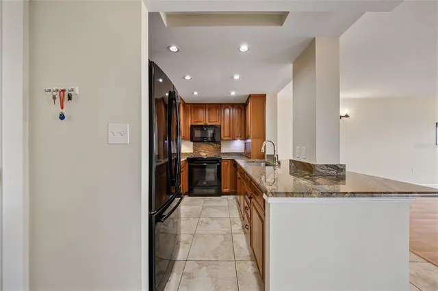 a kitchen with stainless steel appliances granite countertop a sink a stove and a refrigerator