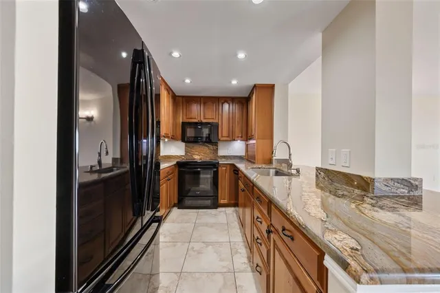 a large kitchen with granite countertop lots of counter top space and stainless steel appliances