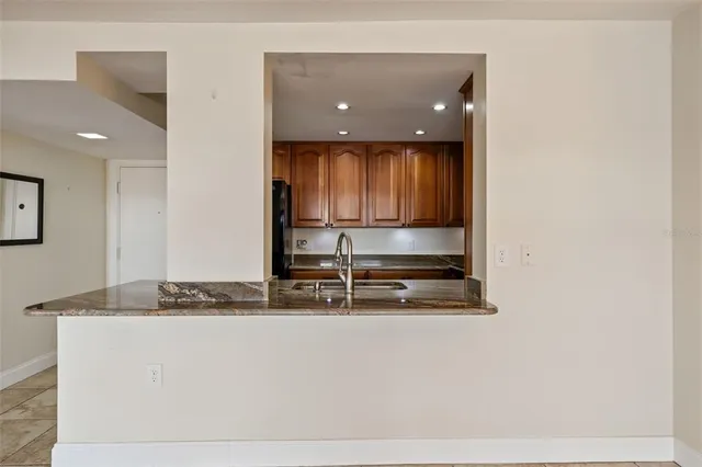 a view of kitchen with granite countertop a sink and a stove