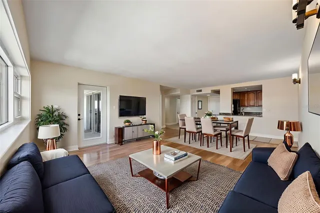 a living room with furniture a flat screen tv and a large window