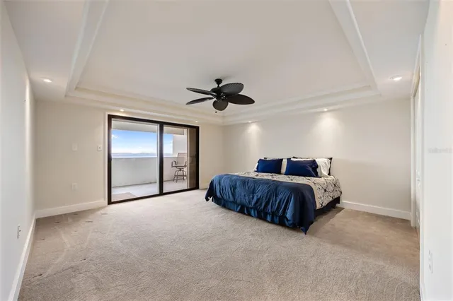 a spacious bedroom with a bed and a ceiling fan