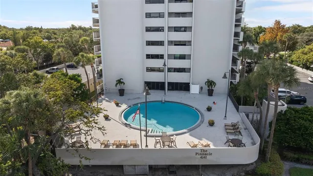 an aerial view of a swimming pool with outdoor seating and plants