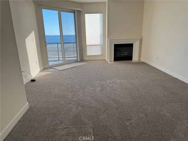 an empty room with windows and fireplace