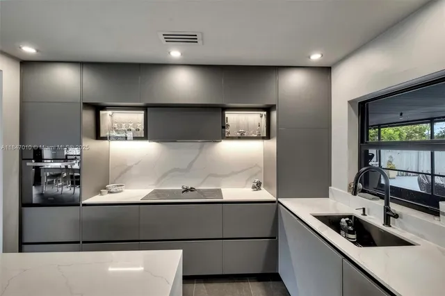 a kitchen with kitchen island a counter space a sink and appliances
