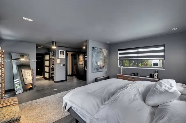a large bedroom with a bed and a large mirror