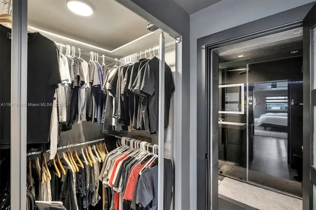 a view of walk in closet with clothes and shoes