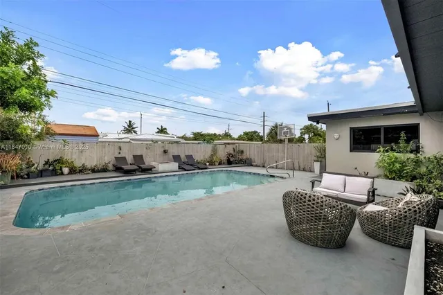 a view of a patio with couches chairs potted plants and palm tree