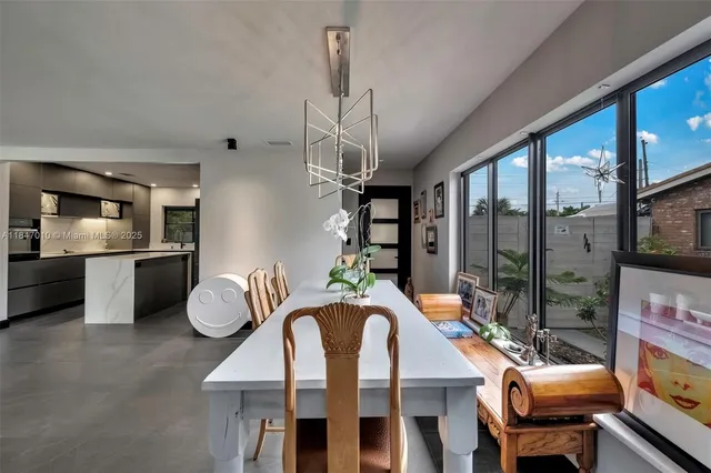 a dining room with furniture a chandelier and window