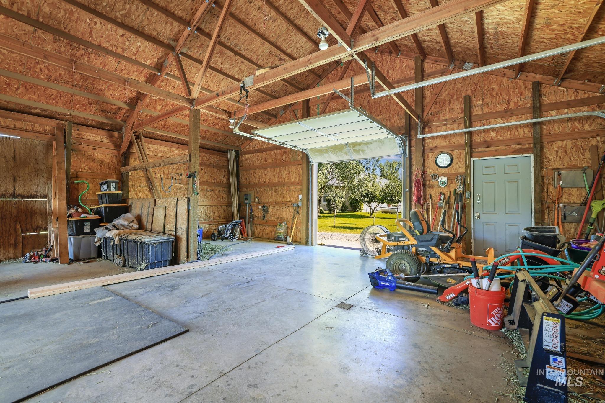 1301 Kanaka Rapids Road Buhl, ID 83316 - Photo 43 of 50 Spacious utility building featuring a concrete slab floor, exposed wood beam ceiling, and a large overhead door