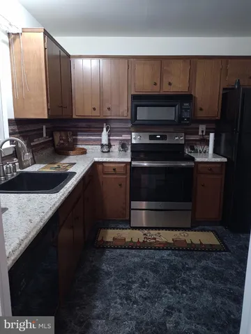 a kitchen with stainless steel appliances granite countertop a sink stove and microwave