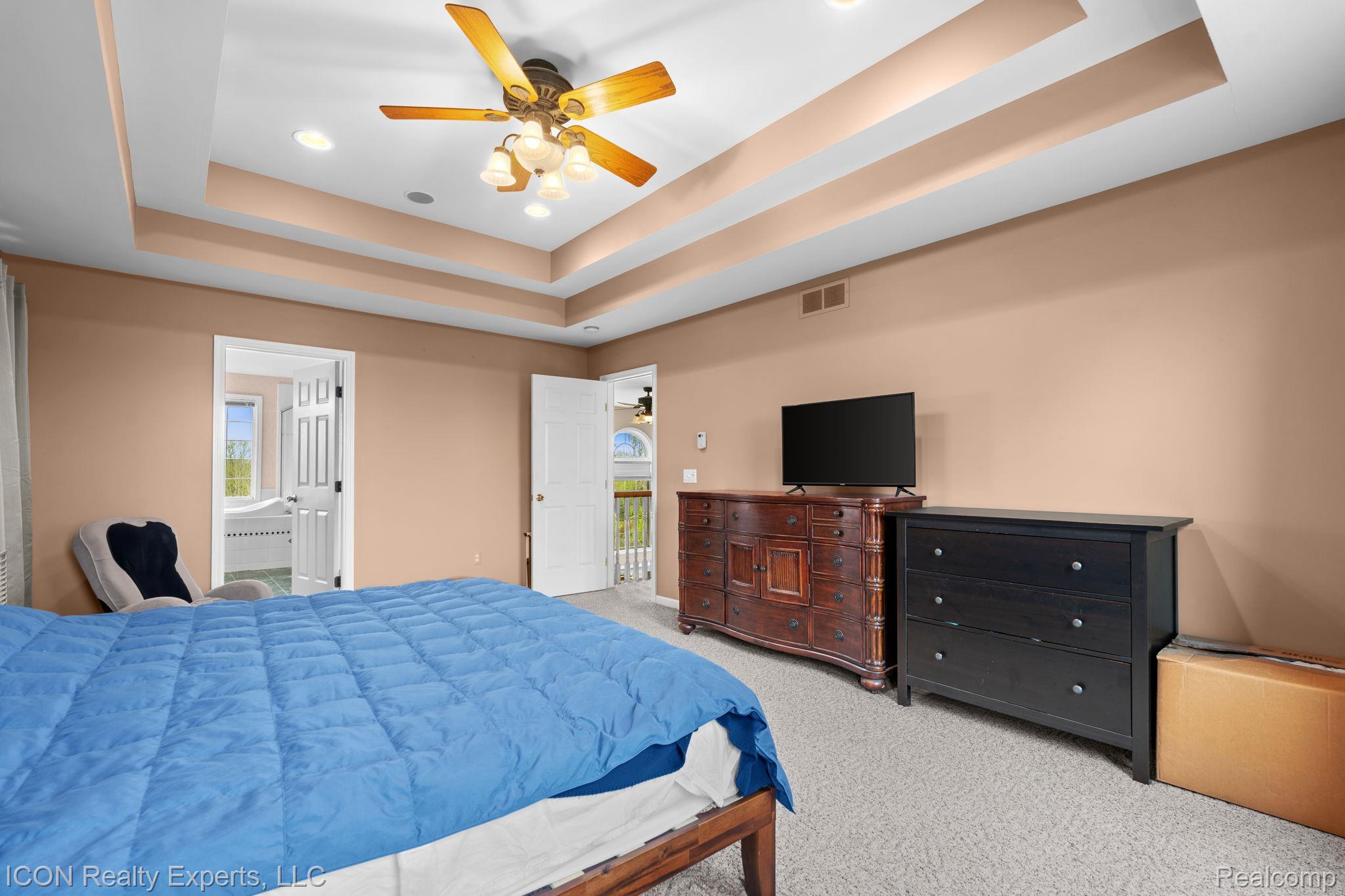 5128 Baldwin Road Metamora, MI 48455 - Photo 31 of 68 Bedroom featuring light colored carpet, recessed lighting, a ceiling fan, multiple windows, and a tray ceiling