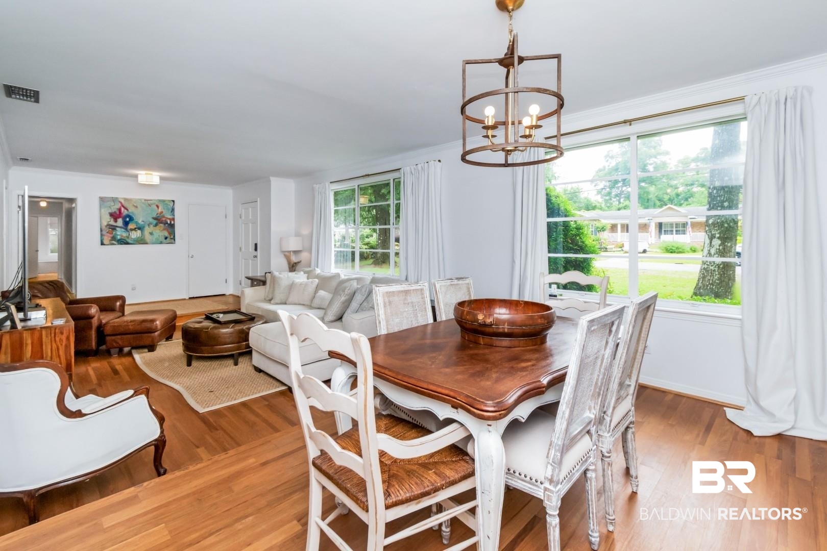 4596 Hawthorne Place Mobile, AL 36608 - Photo 6 of 34 Dining area featuring wood-finish flooring, a decorative chandelier, and large windows with white trim