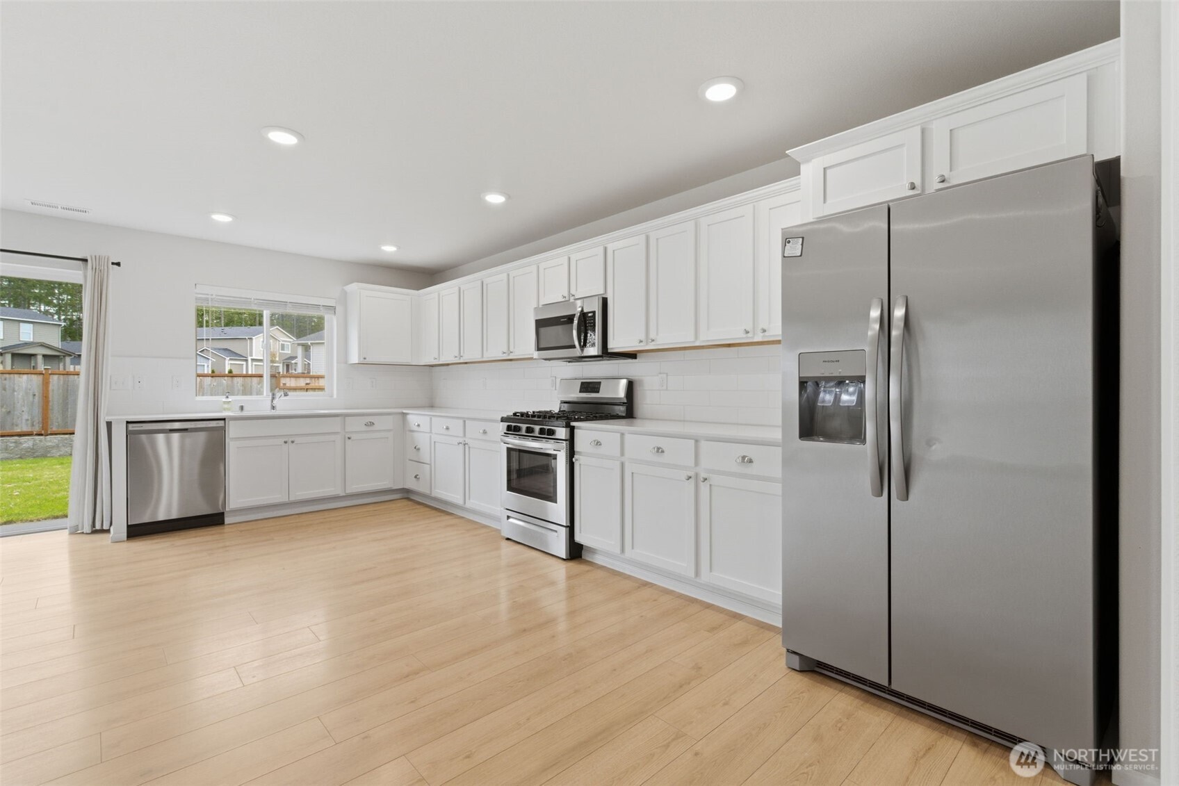 430 Northeast Ridge Point Boulevard Belfair, WA 98528 - Photo 8 of 39 a kitchen with white cabinets and stainless steel appliances
