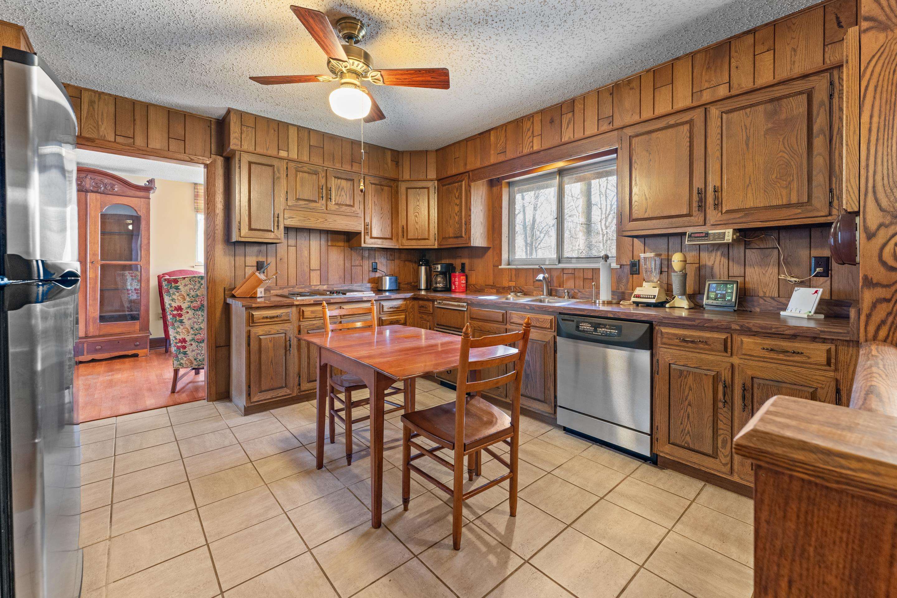 2989 Little John Road Millington, TN 38053 - Photo 11 of 34 a kitchen with stainless steel appliances granite countertop a stove top oven a sink a dining table and chairs with wooden floor