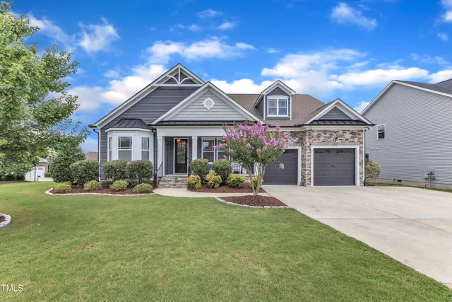 a front view of a house with a garden and yard