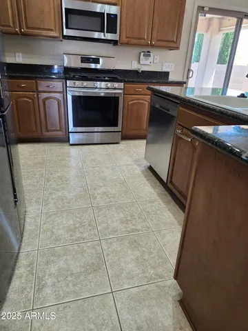 a kitchen with stainless steel appliances granite countertop a stove a sink and a microwave