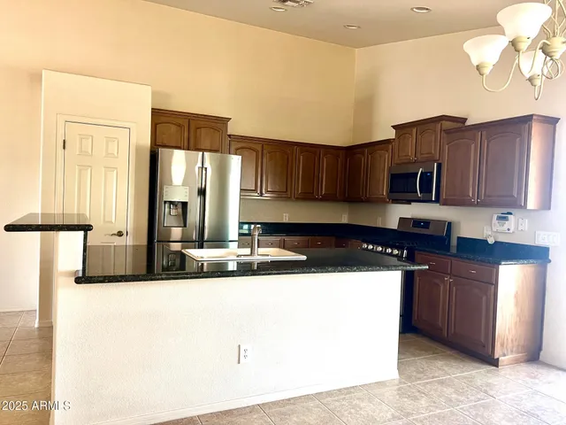 a kitchen with stainless steel appliances granite countertop a sink and a stove
