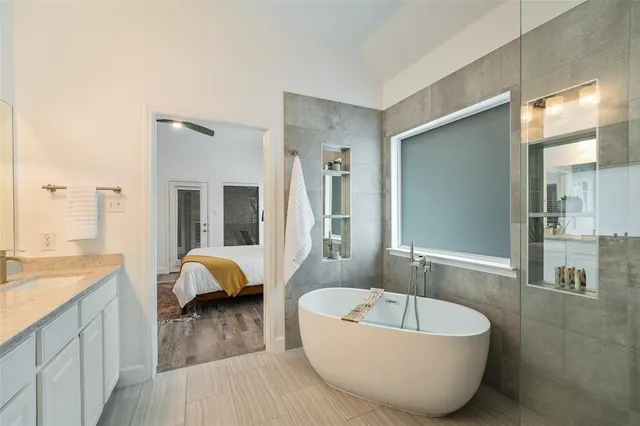 a en suite bathroom with a granite countertop sink and a mirror