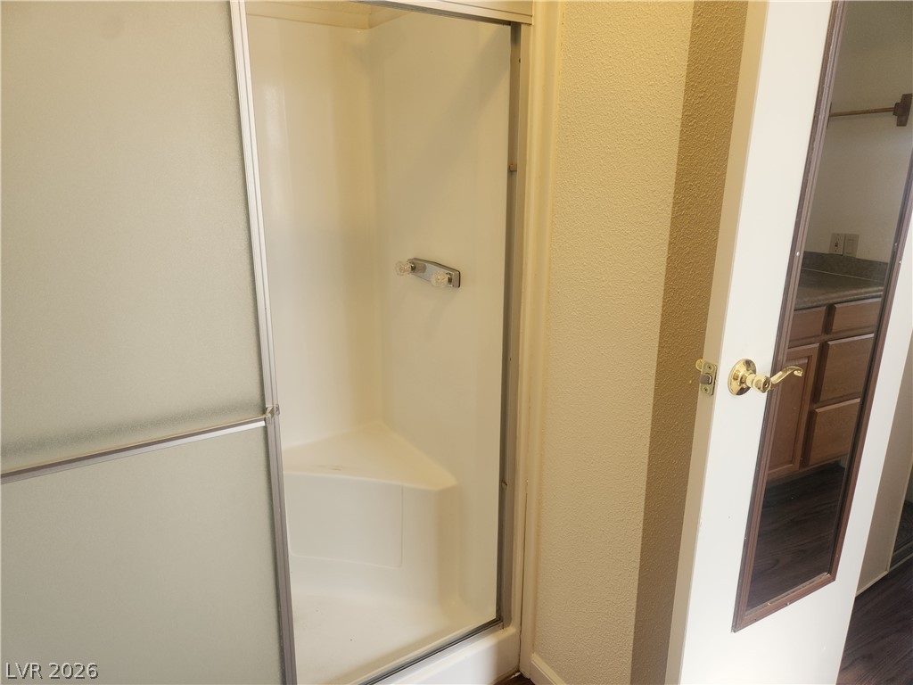 3189 Del Monte Street Laughlin, NV 89029 - Photo 17 of 32 A corner shower with sliding frosted glass doors and built-in bench seating provides a private bathing experience.