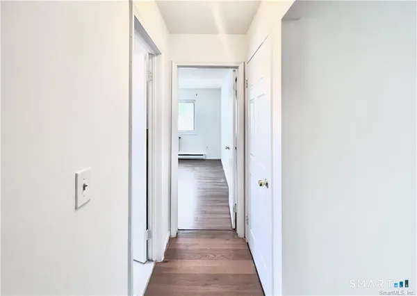 a view of a hallway with wooden floor