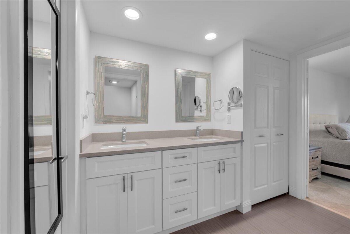 300 North Hwy A1A, Unit 103M Jupiter, FL 33477 - Photo 13 of 25 a bathroom with a double vanity sink and mirror