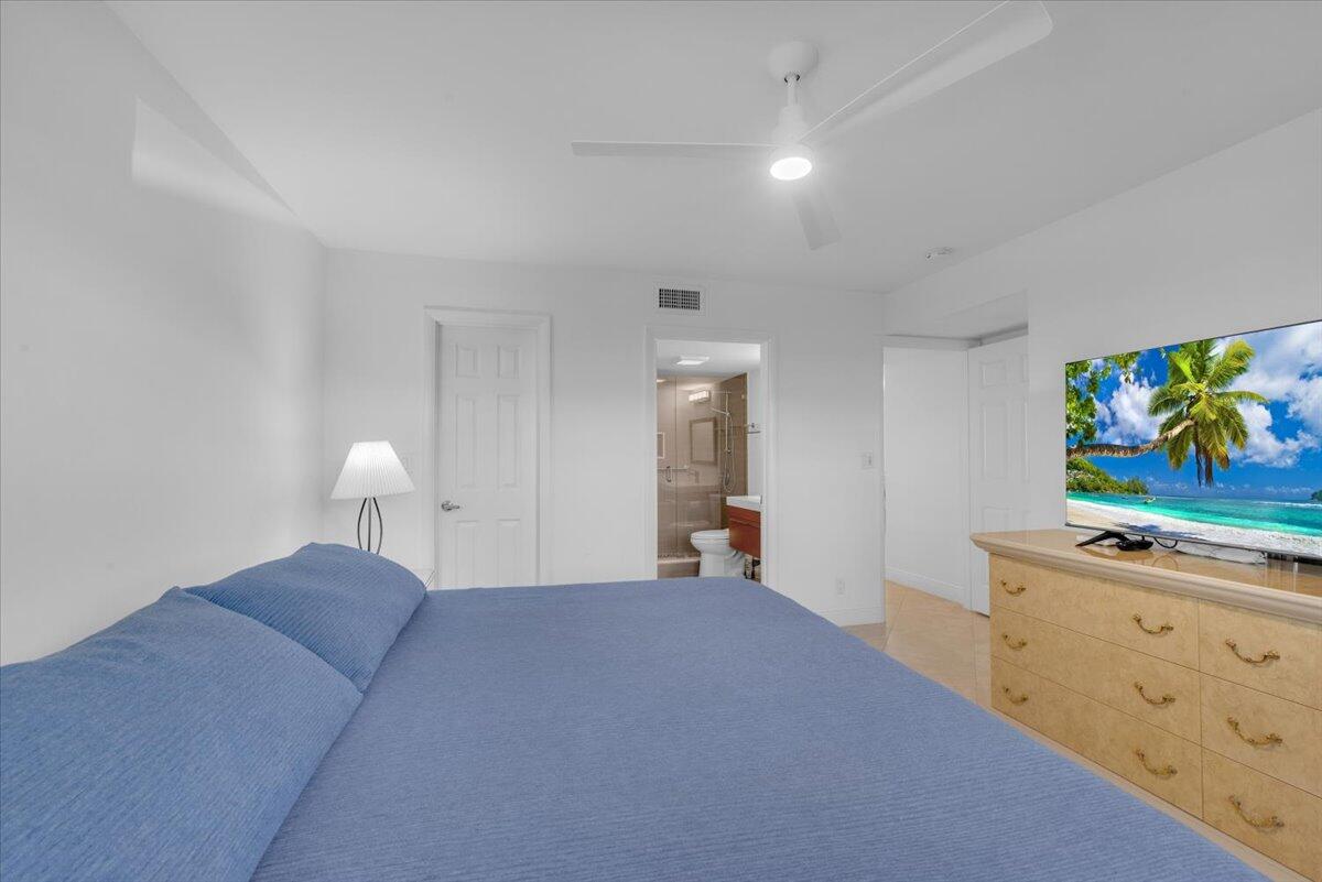 300 North Hwy A1A, Unit 103M Jupiter, FL 33477 - Photo 16 of 25 a bed room with a bed and painting on the wall