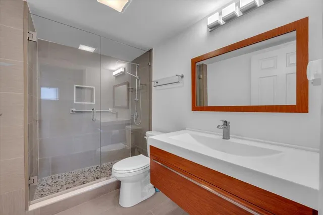 a bathroom with a sink a toilet and shower
