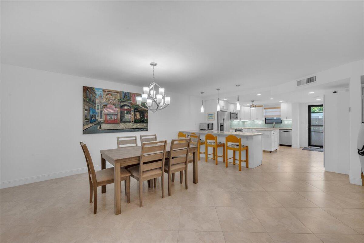 300 North Hwy A1A, Unit 103M Jupiter, FL 33477 - Photo 6 of 25 a view of a dining room with furniture and chandelier