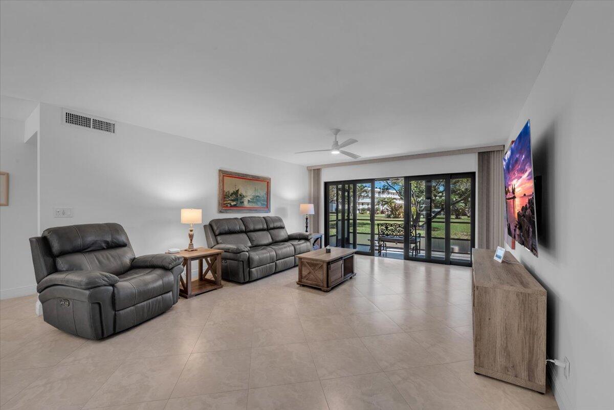 300 North Hwy A1A, Unit 103M Jupiter, FL 33477 - Photo 8 of 25 a living room with furniture large window and flat screen tv