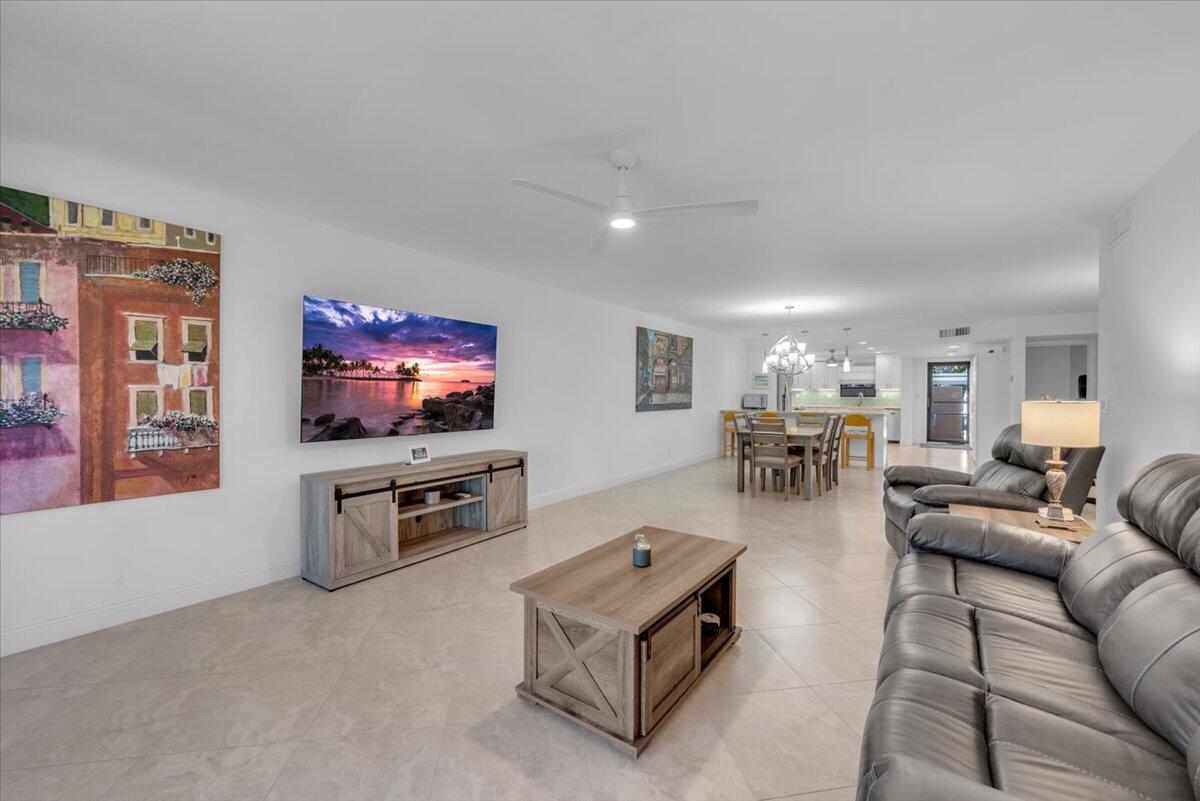 300 North Hwy A1A, Unit 103M Jupiter, FL 33477 - Photo 9 of 25 a living room with furniture and a flat screen tv
