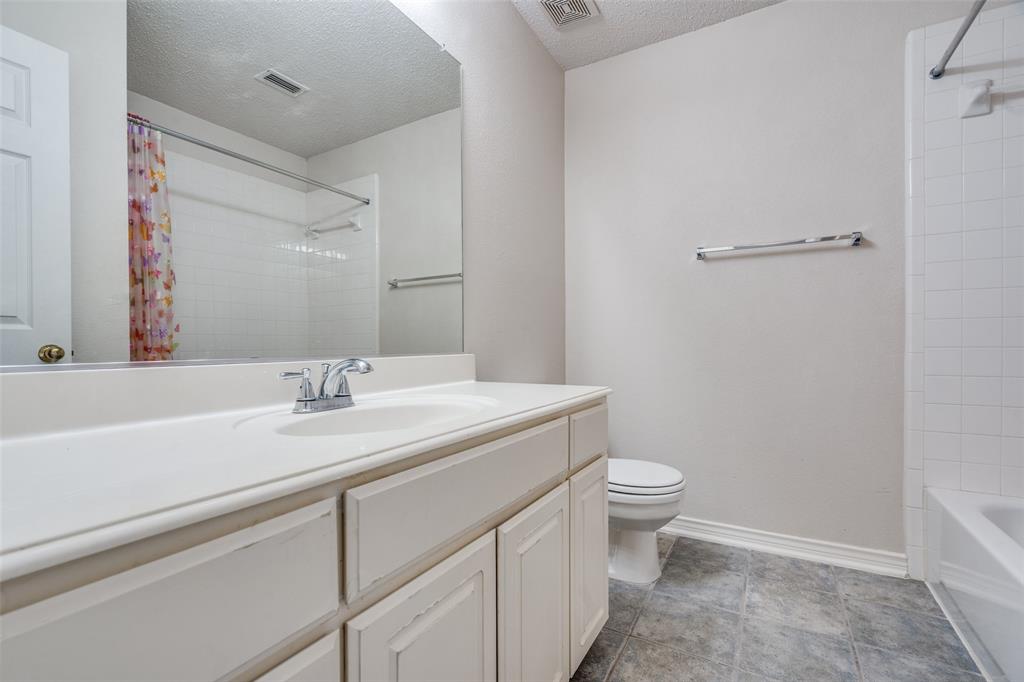 3421 Neiman Road Plano, TX 75025 - Photo 32 of 40 Full bathroom featuring vanity, a textured ceiling, and shower / tub combo with curtain