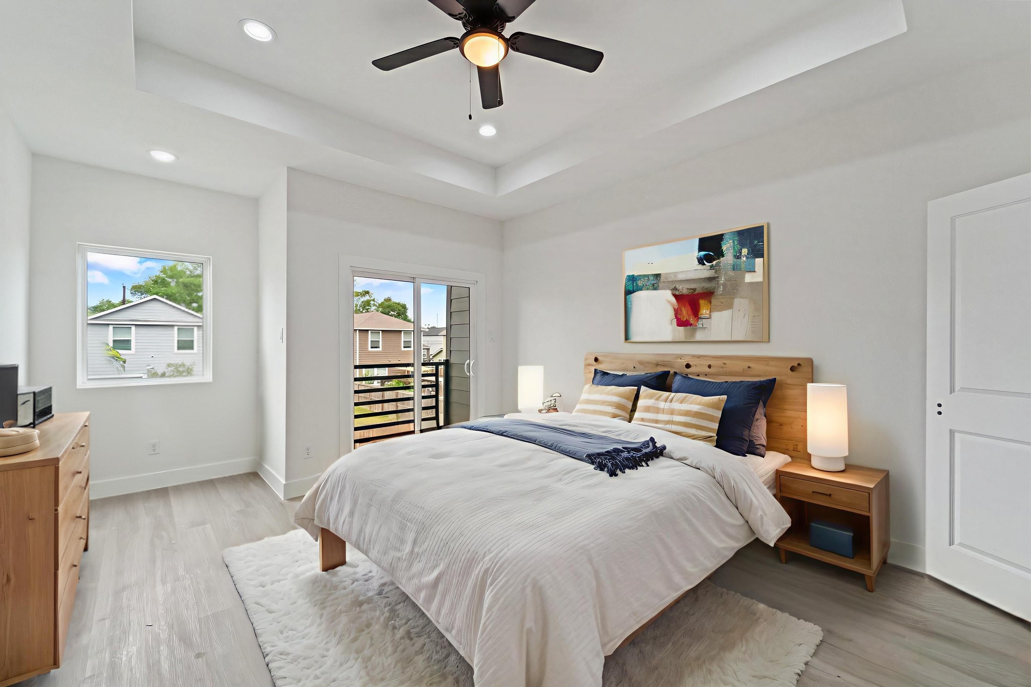 7709 Willow Street Houston, TX 77088 - Photo 6 of 15 This view of the primary bedroom highlights the large window and a sliding glass door providing access to an exterior balcony.