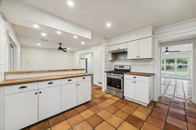 a kitchen with stainless steel appliances granite countertop a stove a sink and a refrigerator