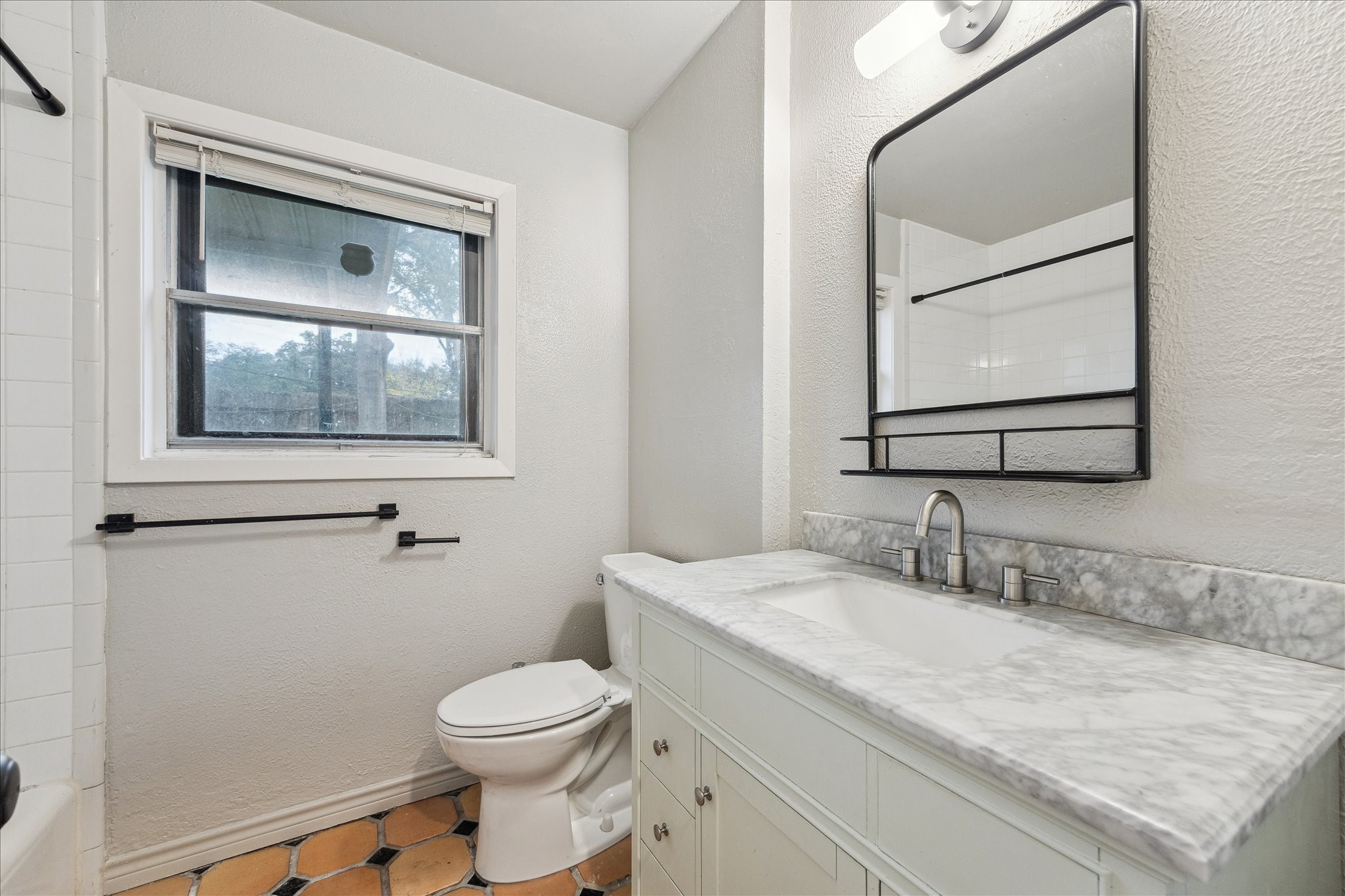 7262 Roos Road Houston, TX 77074 - Photo 21 of 25 a bathroom with a granite countertop toilet a sink and mirror