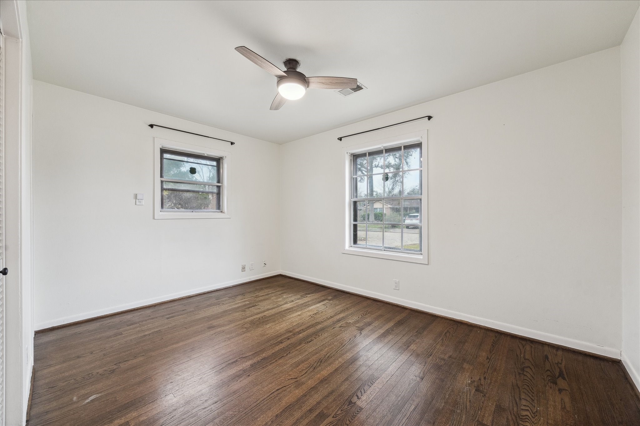7262 Roos Road Houston, TX 77074 - Photo 22 of 25 a view of an empty room with wooden floor and a window