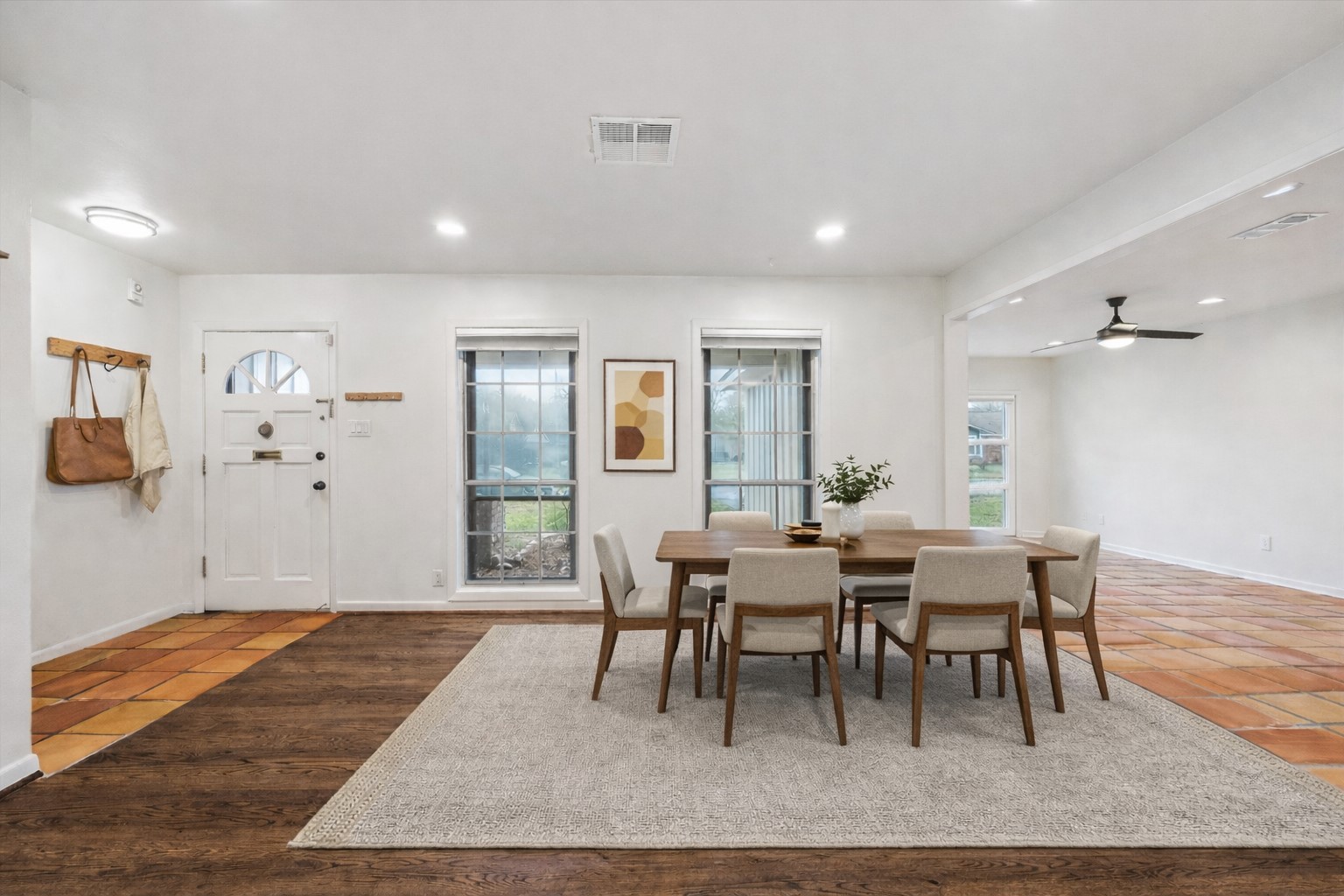 7262 Roos Road Houston, TX 77074 - Photo 4 of 25 a dining room with wooden floor a chandelier a wooden table and chairs