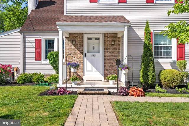 a front view of a house with a yard and potted plants