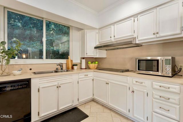 a kitchen with white cabinets and appliances