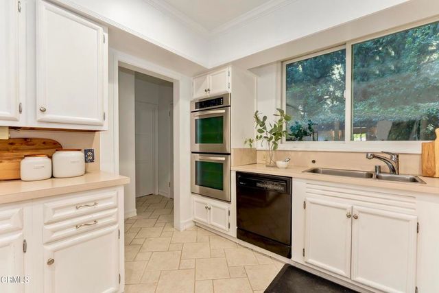 a kitchen with granite countertop a stove a sink and a microwave