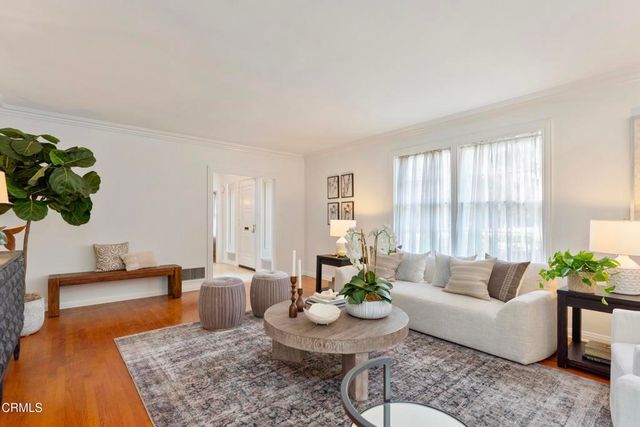 a living room with furniture potted plant and window